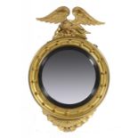 A VICTORIAN GILTWOOD CIRCULAR MIRROR, LATE 19TH C  with convex plate and cavetto frame crested by an