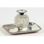 AN EDWARD VII SILVER MOUNTED CUT GLASS INKWELL AND GADROONED STAND, CHESTER 1901, 2OZS 10DWTS