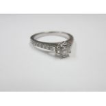 A DIAMOND SOLITAIRE RING WITH DIAMOND SHOULDERS in platinum, size H Sold with GIA Report: 0.50ct,