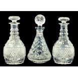 A PAIR OF CUT GLASS DECANTERS AND MUSHROOM SHAPED STOPPERS, AND ONE OTHER