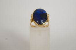 A black opal ring, set in yellow metal,
