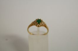 An emerald and diamond cluster ring, the