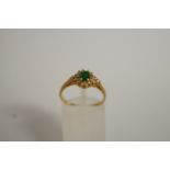 An emerald and diamond cluster ring, the