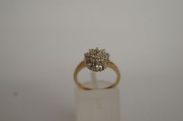 A diamond claw set cluster ring, stamped