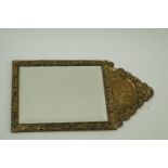 A brass mounted mirror decorated with a