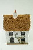 A decorative model of a thatched cottage