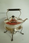 A silver plated spirit kettle on a stand