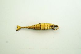A flexi fish charm, with cabochon set ey