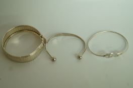 A silver bracelet; with a torque bangle,