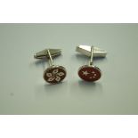 Two single cufflinks, both with circular