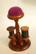 A wooden cotton reel holder with pin cus