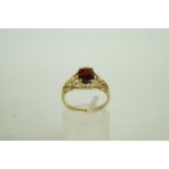 A garnet single stone 9ct gold dress rin