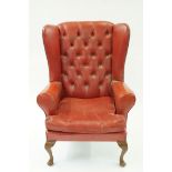 A faux leather wing back armchair