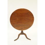 A 19th century elm tilt top table on tri