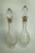 A pair of glass decanters with silver co