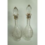 A pair of glass decanters with silver co