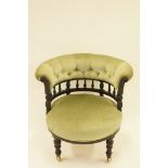 An Edwardian tub shaped aesthetic movement nursing chair on ceramic casters