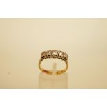 A five stone diamond ring, stamped '18ct' and 'Plat', the graduated old cut stones illusion set,