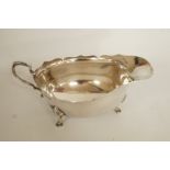 A silver sauce boat, Walker and Hall, Chester 1938, of usual cut rim form, on three supports, 15.5