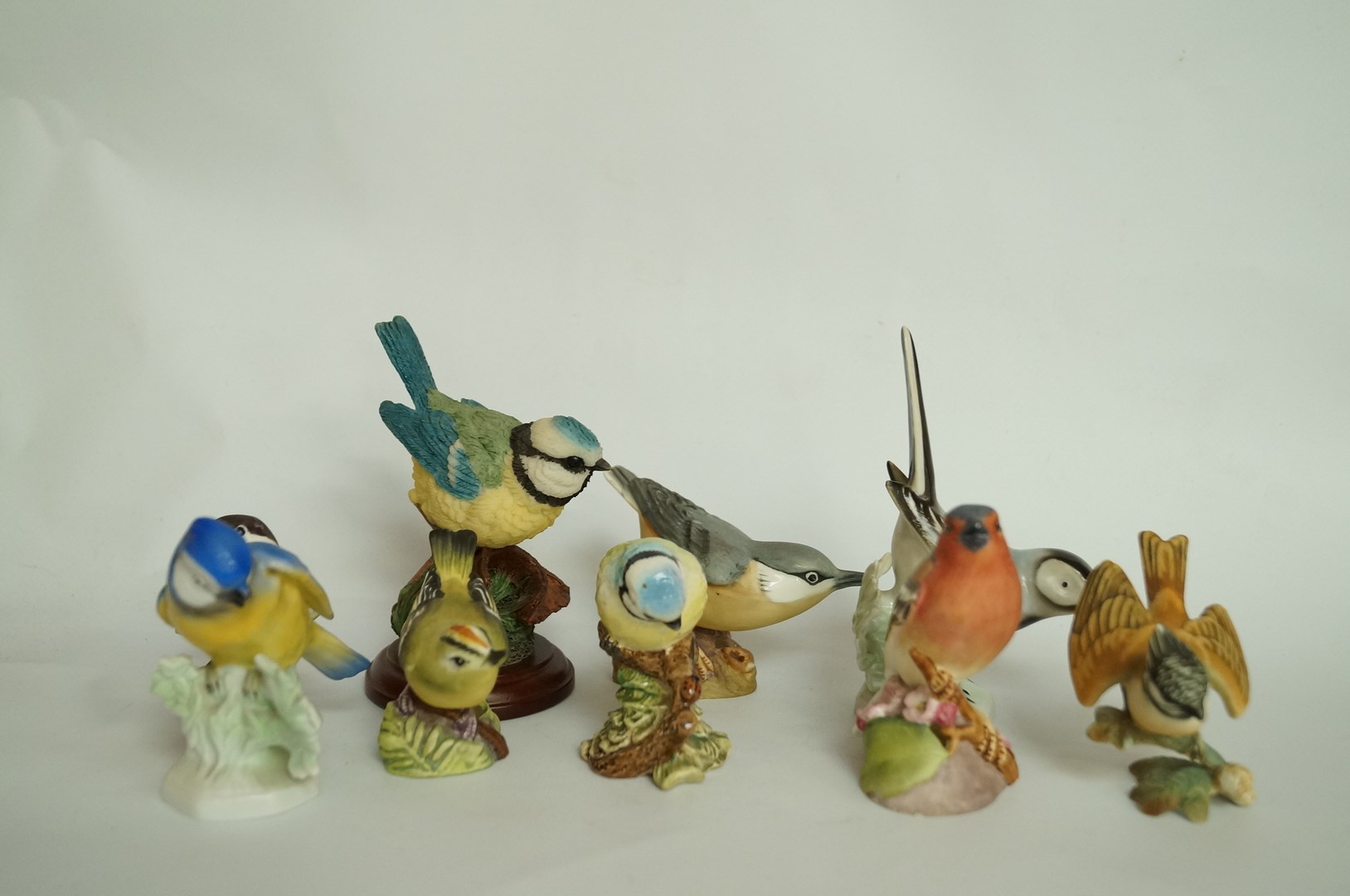 A collection of ceramic figures of birds including Beswick, Royal Doulton and Royal Worcester, nine