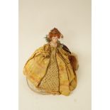 A painted plaster doll dressed in Elizabethan costume on a wooden plinth, H 42cm