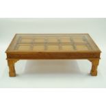 A modern glass and teak coffee table, H 48cm W 149cm D 88cm