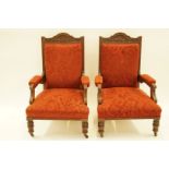 A pair of Edwardian mahogany framed armchairs on turned legs with ceramic casters