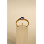 A tanzanite and diamond three stone ring, stamped '14K', the round cut stone of approximately 4.2