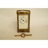 A brass carriage clock with white enamel dial and key, H 15.5cm overall