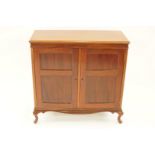 An early 20th century mahogany cabinet with two panelled doors, enclosing two shelves on cabriole