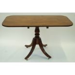 A mahogany rectangular tilt-top breakfast table, the turned centre column standing on four out