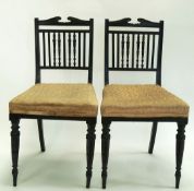 A pair of Edwardian aesthetic movement chairs with ebonised turned uprights and legs