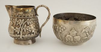 An Indian silver coloured milk jug and sugar basin, with embossed landscape decoration, 164g (5.