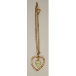 A heart shaped pendant, of open design with a peridot coloured drop within,