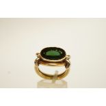 A tourmaline ring, the oval flat cut stone top a heavy two colour mount stamped '14K',