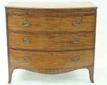 A George III mahogany bow fronted chest of three long drawers below a brushing side with shaped