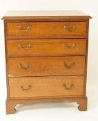 An oak chest of four long drawers with brass handles and bracket feet, 75.5cm high, 64.5cm wide, 41.