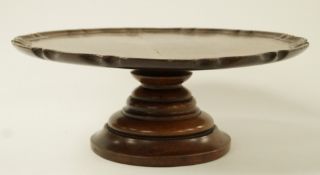 A 20th century mahogany lazy Susan, pie crust edge on a raised circular swivelling support,