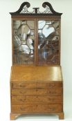 An early 19th century mahogany bureau bookcase with pierced swan neck pediment,