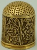 An early 17th century 18ct gold thimble, unmarked, with wire work decoration,