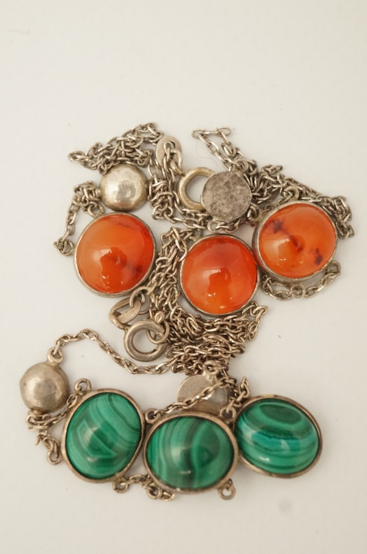 A malachite and white metal necklace and another set with cornelian