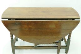 A Jacobean oak gateleg table with turned legs linked by stretchers, 70.5cm high, 115.