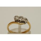 A three stone diamond ring, stamped '18ct', the graduated single cuts illusion set, finger size K,