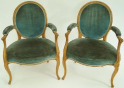 A pair of 18th century elbow chairs, in Louis XV style with carved frames and upholstered backs,