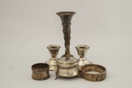 A pair of loaded silver desk candlesticks; with a silver trinket box; two silver napkin rings;