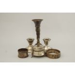 A pair of loaded silver desk candlesticks; with a silver trinket box; two silver napkin rings;