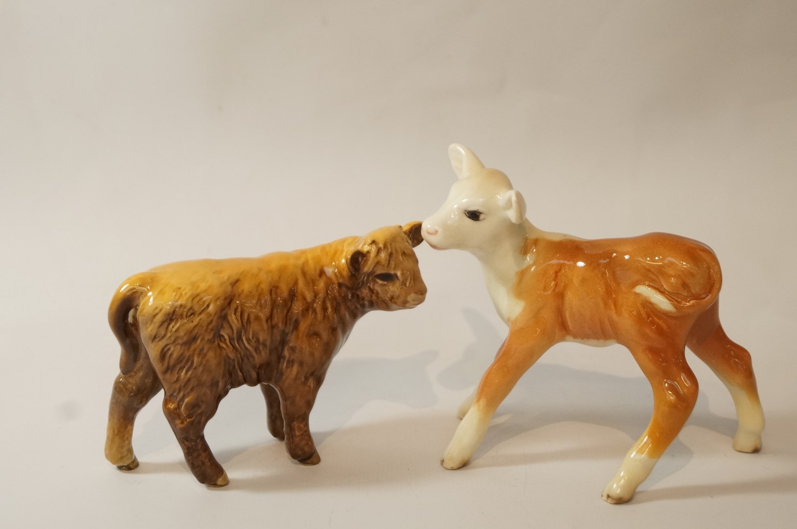 A Beswick Highland calf, no. 1827D, 7.5cm high and a Beswick Hereford calf, no.