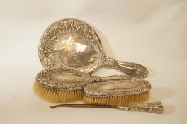 A silver dressing table set, comprising a hand mirror,