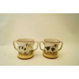 A pair of 19th century loving cups, each decorated with a dog carrying a pheasant,