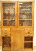 A 20th century oak draftman's cabinet with two glazed doors above a central panelled door flanked